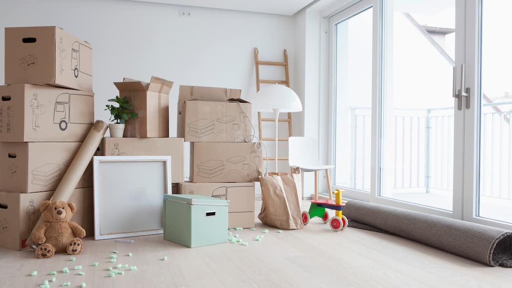 Ich darf rein, du musst raus Leeres Wohnzimmer mit gestapelten Umzugskartons