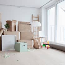 Ich darf rein, du musst raus Leeres Wohnzimmer mit gestapelten Umzugskartons