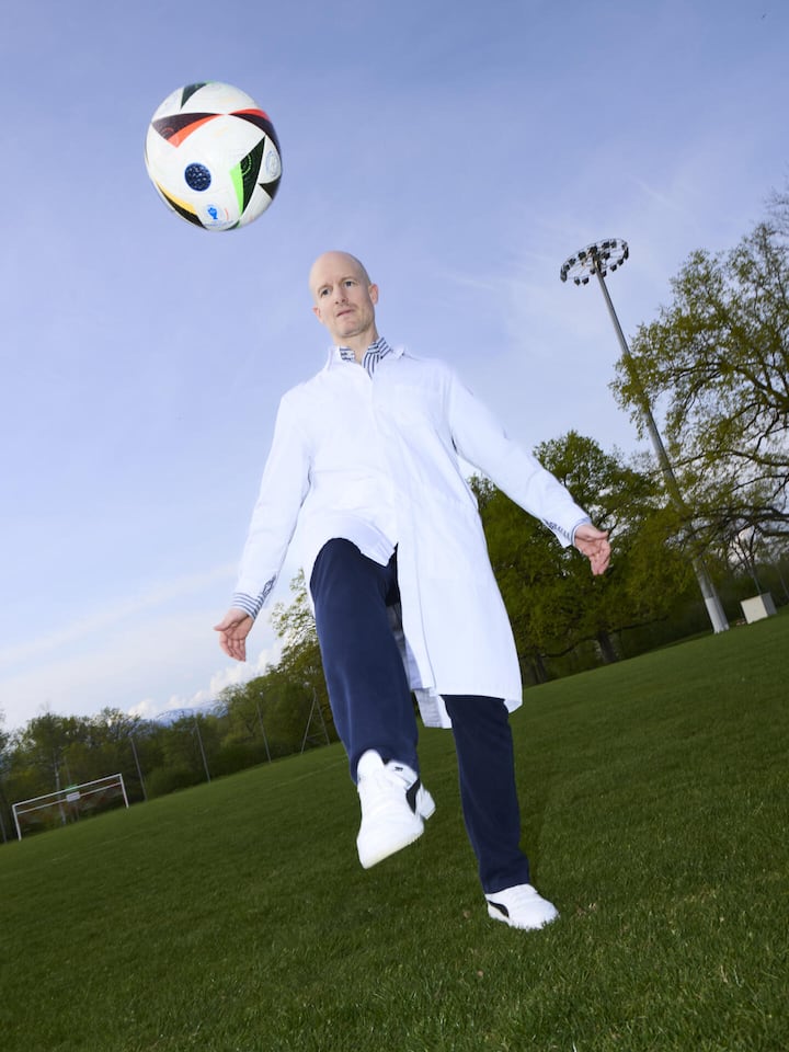 ... leiden Sie mit, wenn unsere Nati-Spieler gefoult werden? Philippe Tscholl jongliert mit einem Fussball - Für die Schweizer Fussball-Nati steht die Gesundheit an erster Stelle: Teamarzt Philippe Tscholl bereitet die Spieler auf die WM in Nordamerika vor – inklusive Jetlag-Training