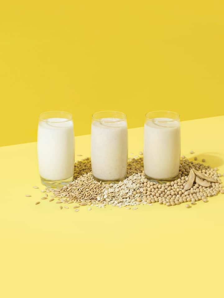 Körner und drei Gläser Milch - Jahrzehntelang war Kuhmilch unantastbar. Doch längst haben Hafer- und Sojadrinks die Regale erobert, nicht nur im «Veganuary». Wo die Pflanze punktet und wo die Kuh unschlagbar bleibt