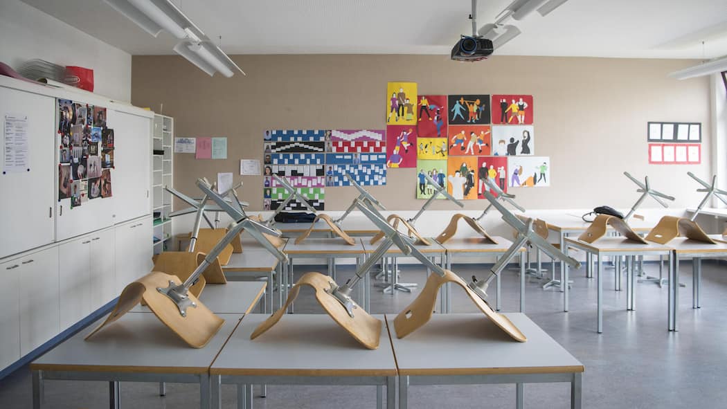 Jetzt will der Lehrerverband echte Hitzeregeln an Schulen Stühle auf Pulten im Klassenzimmer - Während im Büro klare Temperaturregeln gelten, schwitzen Schulkinder bei bis zu 35 Grad im Unterricht. Der Lehrerverband fordert nun einen Hitzeplan für Klassenzimmer