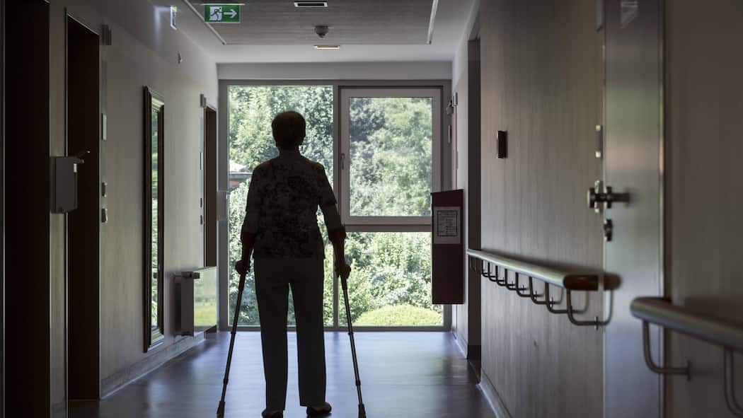 Prämien für Spitalzusatz – günstig beim Abschluss, ruinös im Alter Ältere Frau geht im Spital an Krücken