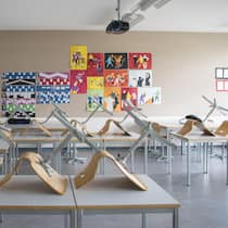 Jetzt will der Lehrerverband echte Hitzeregeln an Schulen Stühle auf Pulten im Klassenzimmer - Während im Büro klare Temperaturregeln gelten, schwitzen Schulkinder bei bis zu 35 Grad im Unterricht. Der Lehrerverband fordert nun einen Hitzeplan für Klassenzimmer