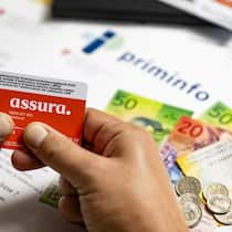 33 Prozent der Haushalte kämpfen mit Prämien der Krankenkassen Versicherungskarte und Geldnoten - Für viele Menschen in der Schweiz wird die monatliche Krankenkassenrechnung zur Belastung.Wer nicht zahlt, landet schneller in der Schuldenspirale als gedacht