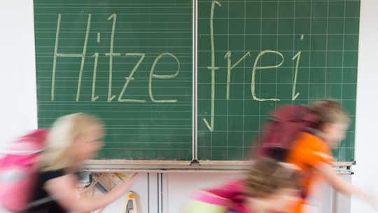 ARCHIV - 30.06.2015, Sachsen, Dresden: ILLUSTRATION - Sch¸ler einer 2. Klasse laufen in einer Grundschule an einer Tafel mit der Aufschrift "Hitzefrei" vorbei. (zu dpa vom 23.06.2019) Foto: Sebastian Kahnert/dpa-Zentralbild/dpa +++ dpa-Bildfunk +++ …
