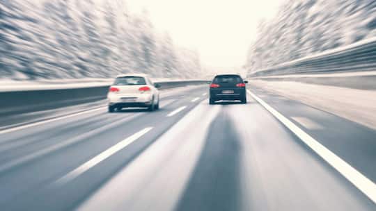 Zwei Autos fahren auf Autobahn im Winter